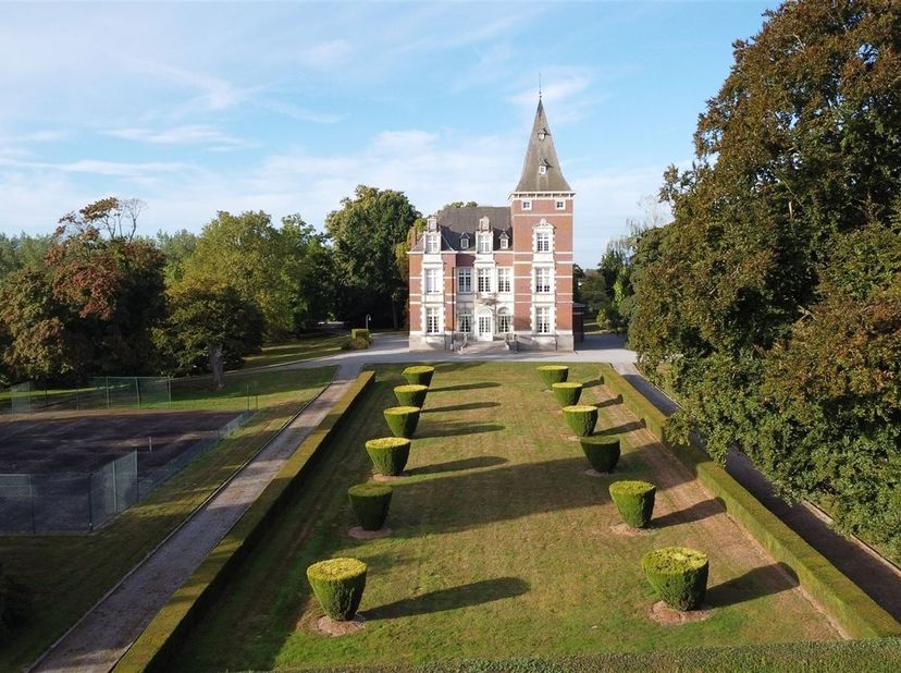 Het kasteel:<br />
De statige toegangspoort en lange oprijlaan leiden naar het kasteel, gebouwd in 1904-1907 in eclectische stijl. In 1988 werd het k