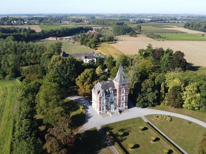 Het kasteel:<br />
De statige toegangspoort en lange oprijlaan leiden naar het kasteel, gebouwd in 1904-1907 in eclectische stijl. In 1988 werd het ka