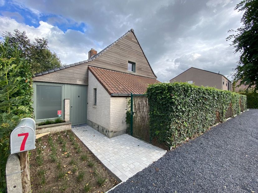Charmante gerenoveerde halfopen woning, rustig gelegen, doch een goede verbinding met E17 (afrit Kruishoutem).<br />
Via de ruime inkomhal, die ook we