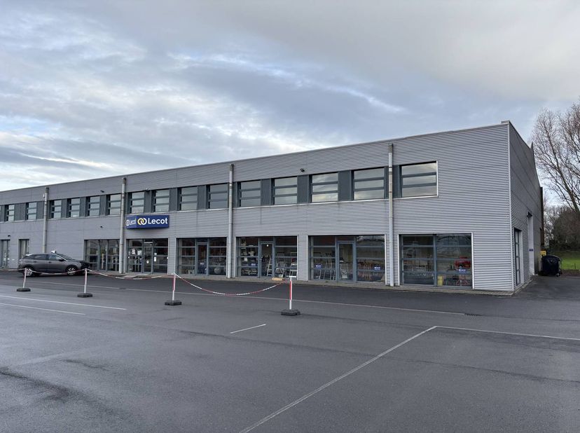 Polyvalent magazijn / handelspand van ca. 1.200m² met bijhorende kantoorruimte / toonzaal van 200m² en ruime voorliggende parking gelegen op een comme
