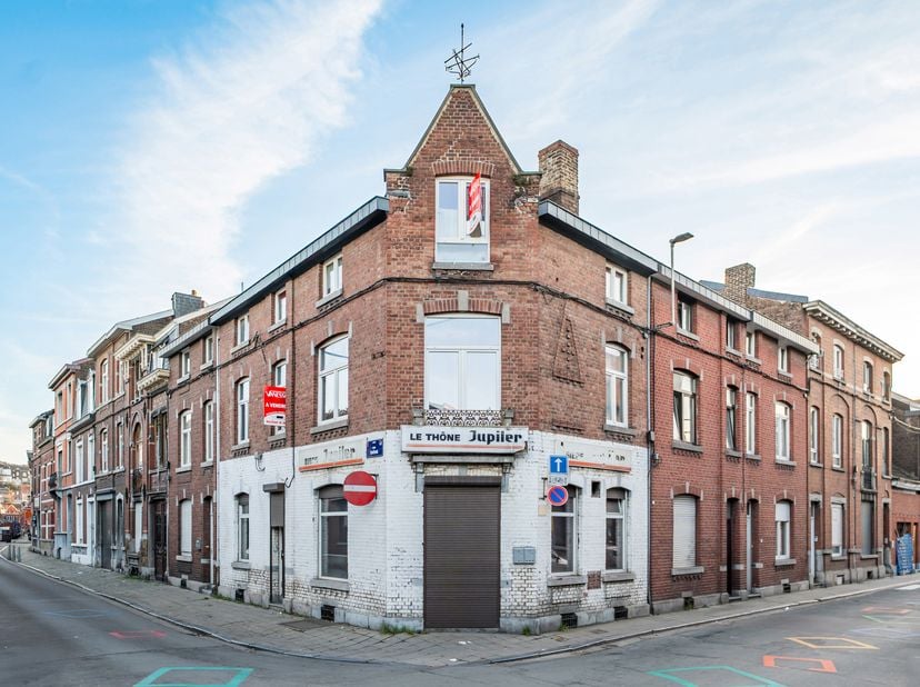 Ce bâtiment est composé d'un commerce au rez-de-chaussée et de 2 appartements loués.<br />
Au rez-de-chaussée, le commerce (anciennement café) a une s