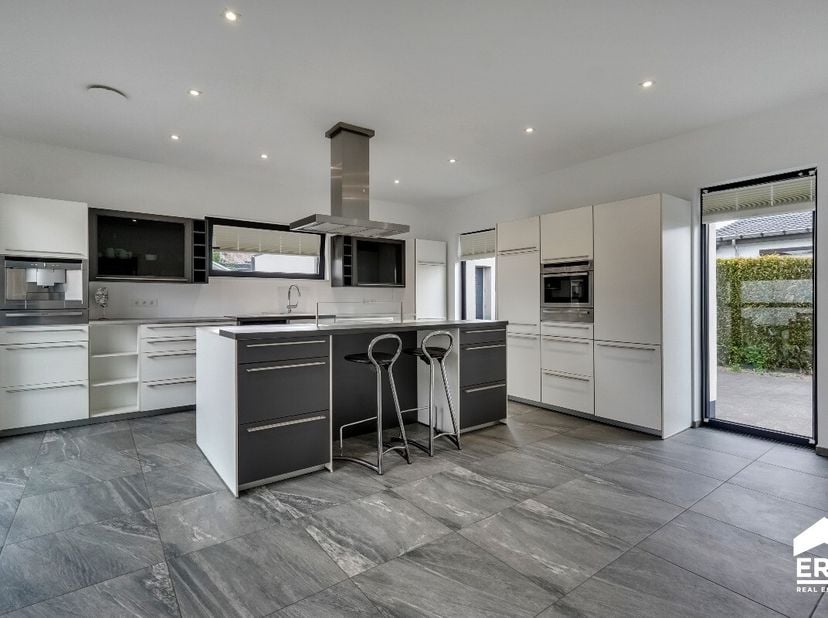 In de Lariksenstraat in Houthalen-Oost bevindt zich deze stijlvolle en energiezuinige gezinswoning met 4 slaapkamers op een perceel van 8 are. De woni