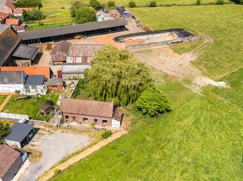 Située dans une impasse du paisible village de Guignies, cette maison 4 façades à rénover totalement est érigée sur un terrain 620m² et laisse entrevo