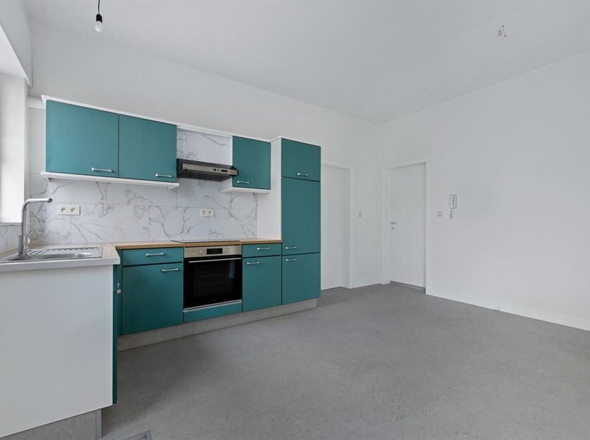 Dit gerenoveerde gelijkvloerse appartement aan de Olympialaan in Sint-Truiden combineert twee volwaardige slaapkamers, een ruime buitenkoer van 36 m²