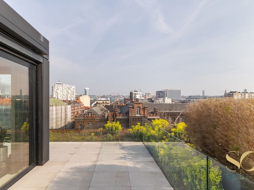 Situé dans le quartier Dansaert, face au canal, au 5ème étage d'un immeuble de 2014, ce penthouse duplex signé par l'architecte Glenn Sesstig offre un