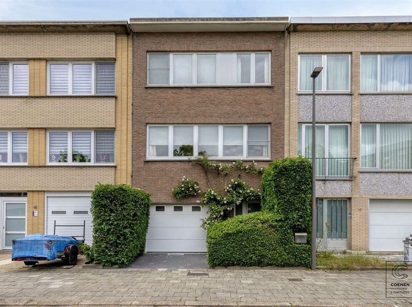 Deze woning verwelkomt u via een riante inkomhal met ingemaakte kasten. Hier bevinden zich een apart gastentoilet, de toegang tot de inpandige garage