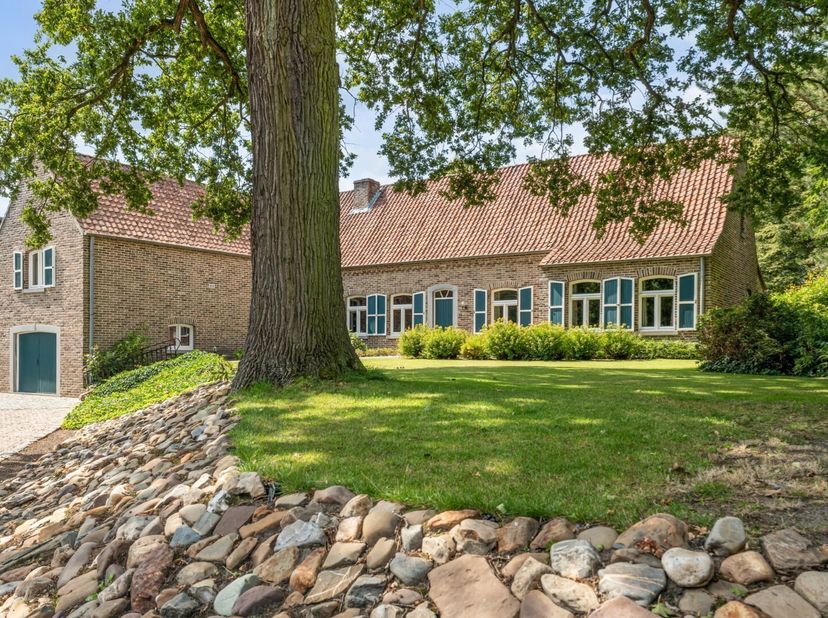 Dit ruime landhuis in een klassieke bouwstijl ademt karakter.  De ligging combineert wonen vlakbij de dorpskern met de rust van een parkachtige tuin.