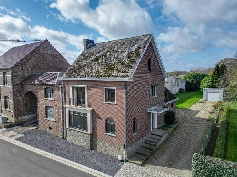 Deze halfopen bebouwing, landelijk en uiterst rustig gelegen, beschikt over vier volwaardige slaapkamers en biedt tal van mogelijkheden om bijkomende