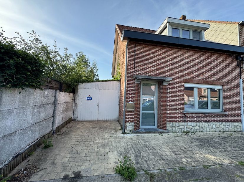 Een knusse woning met tuin er omvattende een kelderberging - GLVL. niv. met inkomhall, keuken met toegang tot de tuin, leefruimte, eetplaats, badkamer