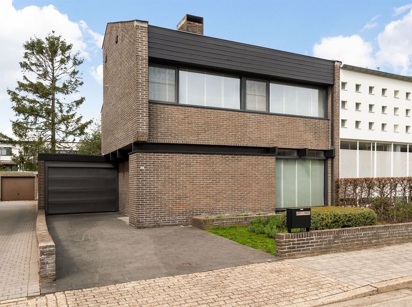 Gezinswoning met 3 slaapkamers, tuin en garage<br />
Gelijkvloers<br />
Via de inkomhal met ingemaakte kast en gastentoilet betreedt u de woning. De l