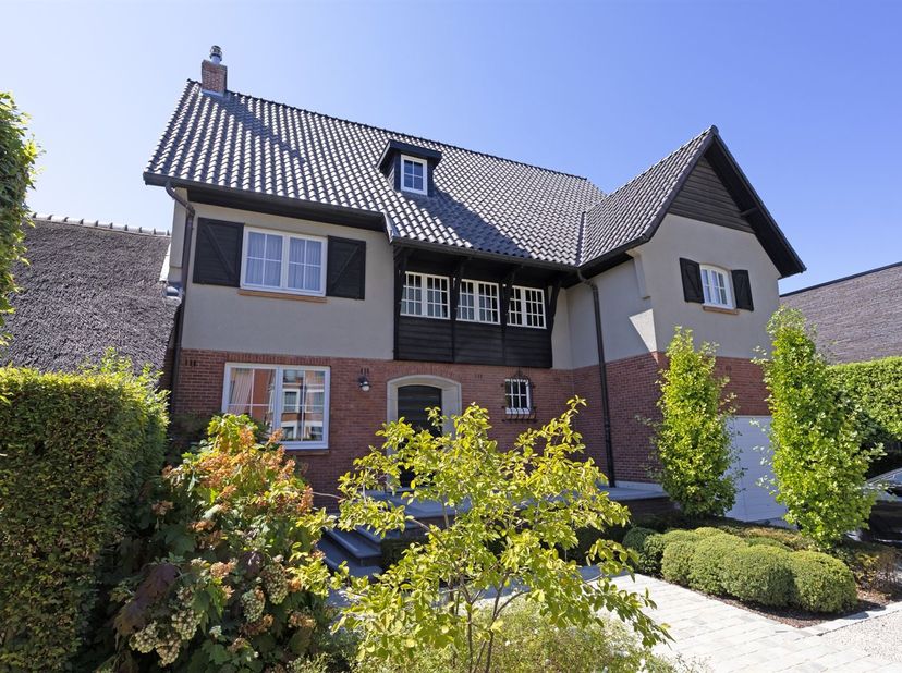 Deze karaktervolle villa in authentieke Engelse cottagestijl werd gebouwd in 1952 en bevindt zich op een volledig aangelegd perceel van circa 6 are 80