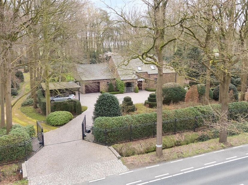 Située au centre, cette villa spacieuse offre un espace de vie lumineux avec une cheminée à gaz et de grandes fenêtres donnant sur le jardin. La cuisi