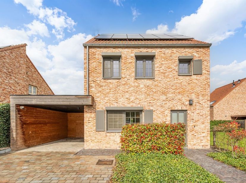 De woning, gebouwd in 2021, verwelkomt u via een inkomhal met apart gastentoilet. Vanuit de hal komt u in de lichtrijke leef- en eetruimte, waar grote