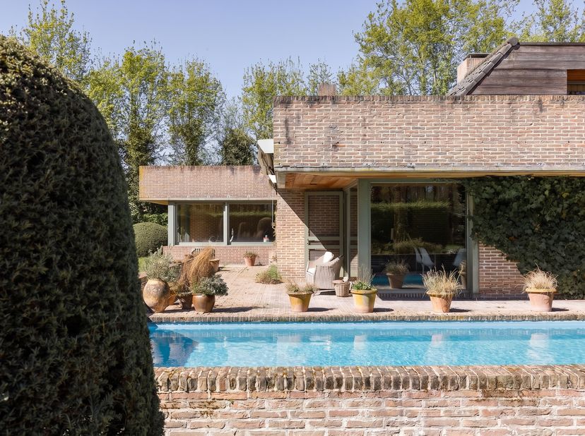 Deze indrukwekkende villa, in 1980 ontworpen door de gerenommeerde architect Degeyter, biedt een unieke kans voor wie houdt van authentieke architectu