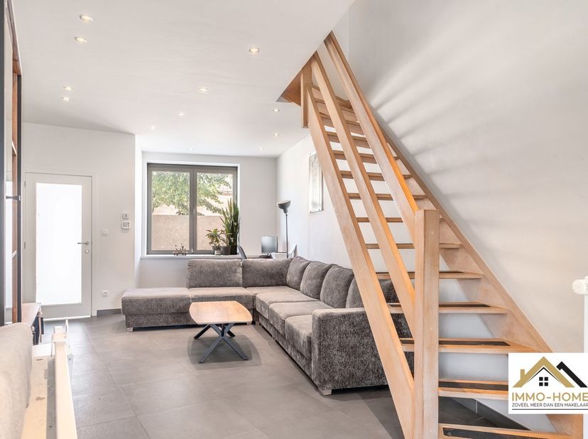 Deze perfect instapklare woning ontvangt je in een handige inkomhal, en zo kom je verder tot in de leefruimte met open keuken. De hoge plafonds zorgen