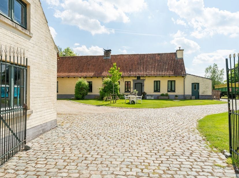 Deze karaktervolle hoeve te Speelstraat 93 in Zingem is opgenomen in de inventaris onroerend erfgoed en ademt authentieke landelijke charme. Het gehee