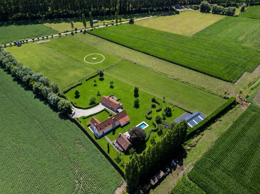 Via een indrukwekkende oprijlaan met kasseien karrespoor bereik je de woning, die zich discreet nestelt in het omliggende landschap. De elegante inkom