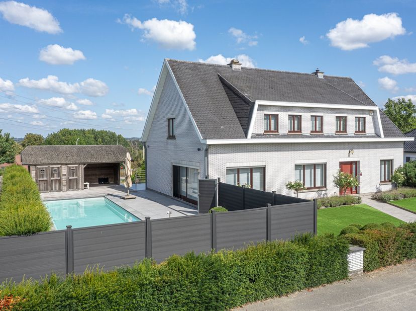Deze ruime villa uit 1980 biedt een mooie combinatie van wonen, ontspanning en tal van extra mogelijkheden. Aan de voorzijde beschikt de woning over e