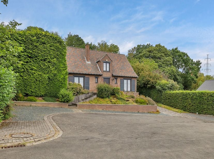 Dans la Potaardestraat, rue calme et verdoyante de Dilbeek, se trouve cette spacieuse villa qui vous donne immédiatement une sensation de retour chez