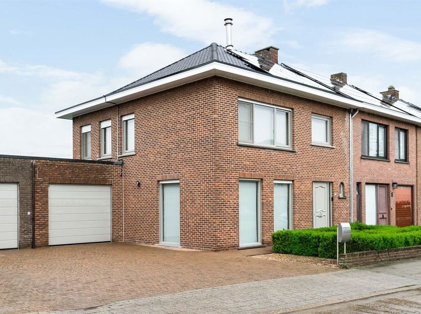 Gezinswoning met 3 slaapkamers, 2 garages en tuin<br />
Gelijkvloers:<br />
Inkomhal met gastentoilet en ingemaakte kasten. Aansluitend bevindt zich d