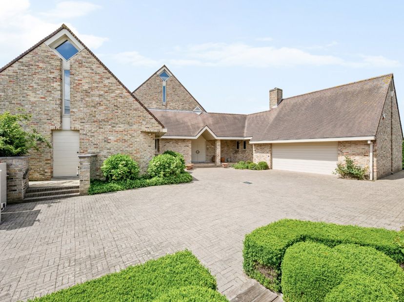 - Villa op een groot hoekperceel (2.510 m²)<br />
- Inkomhal met vestiaire en apart toilet <br />
- Ruime leefruimte met parketvloer en gezellige gash
