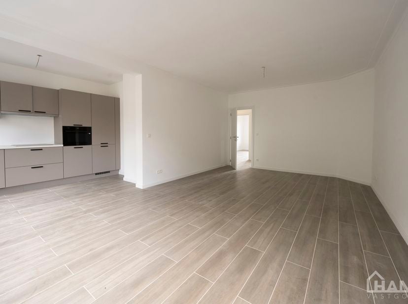 Inkomhal; technische ruimte; leefruimte met open keuken voorzien van kasten en toestellen; badkamer met inloopdouche, wastafel in meubel, spiegel, toi