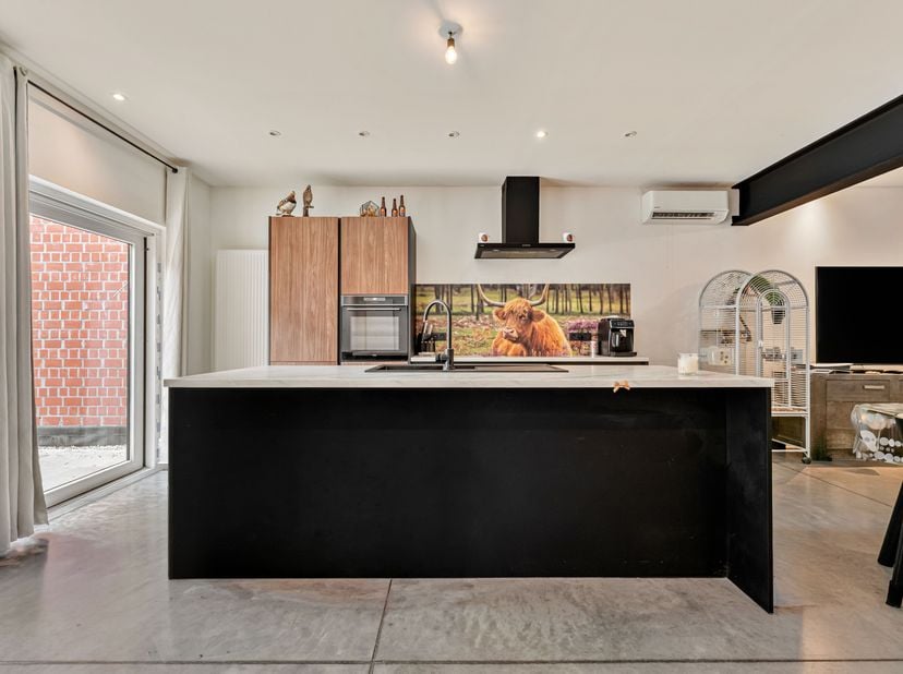 Instapklare woning met industriële stijl te koop in Wevelgem<br />
Je betreedt de woning via de inkomhal met gastentoilet. Vervolgens kom je in de sti