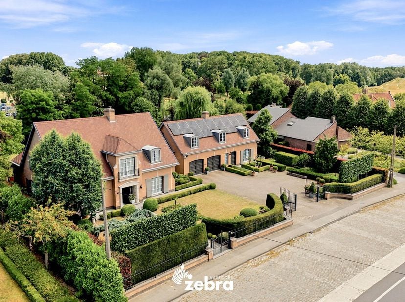 Deze stijlvolle villa bevindt zich op een uitzonderlijk perceel van bijna 3.000 m², op amper vijf minuten fietsen van het centrum van Meulebeke. Een e