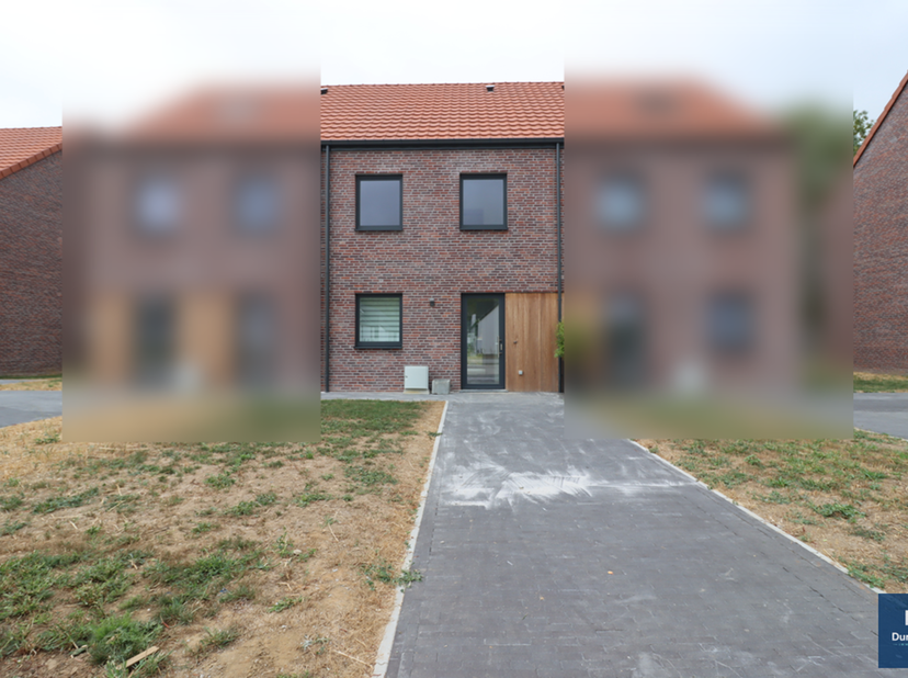 Nieuwbouwwoning met twee gevels, een terras en een door een haag omheinde tuin, gelegen in een rustige woonwijk, vlakbij het stadscentrum van Ath en a