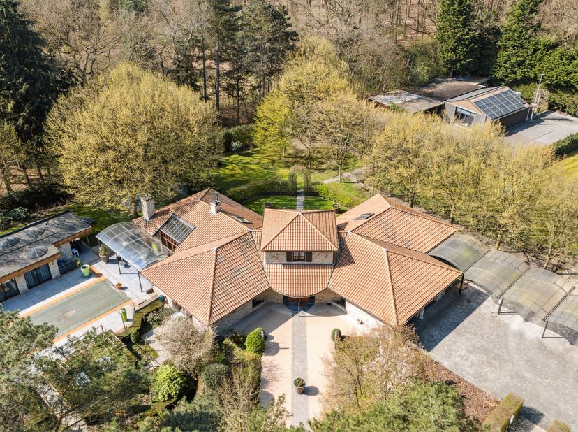 In een rustige en groene omgeving in Schoten bevindt zich deze ruime Spaanse villa op een royaal perceel van 8.670  m². Dit eigendom combineert karakt