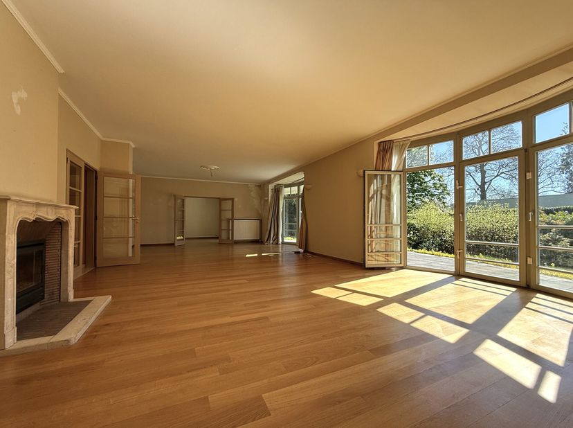 In een rustige en groene omgeving, ruim gelijkvloers appartement in een mooi gebouw met 8 mede-eigenaren. Het biedt een inkomhal/vestiaire/toilet, lic