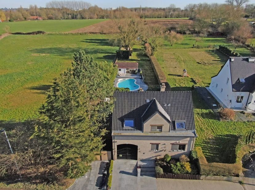 Deze villa (228m²) met drie slaapkamers en zwembad biedt een oase van rust en is gelegen in een rustige Pajotteland te Neerpede. Ze is afgewerkt met h
