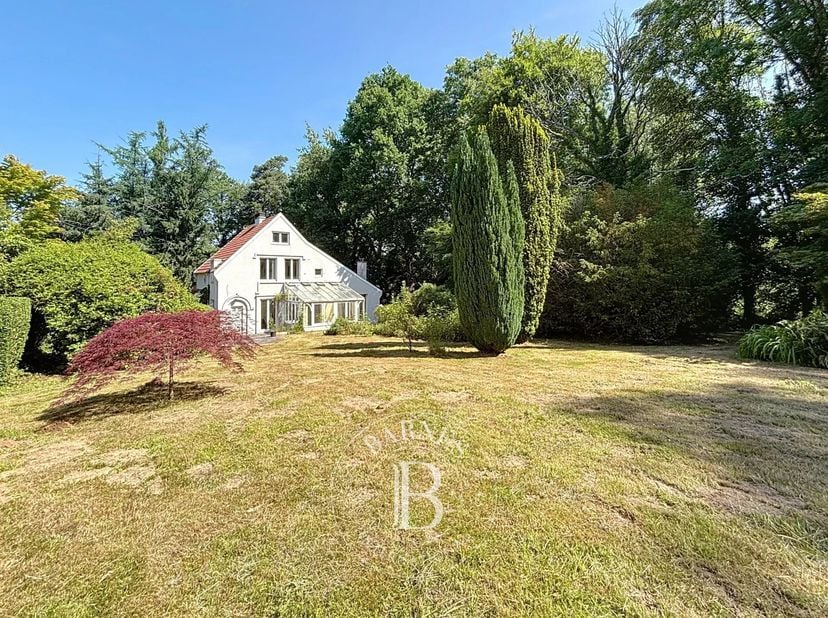 Uccle - Barnes Brussels vous propose cette maison familiale nichée dans un écrin de verdure, au bout d&#039;une allée privative de 100 m, sur un terrain un