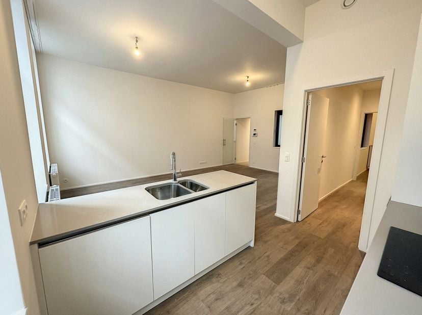 En première occupation, bel appartement 2 chambres de +/- 100m²  situé au 1er étage d’un immeuble entièrement rénové et qui offre à ses résidents tout