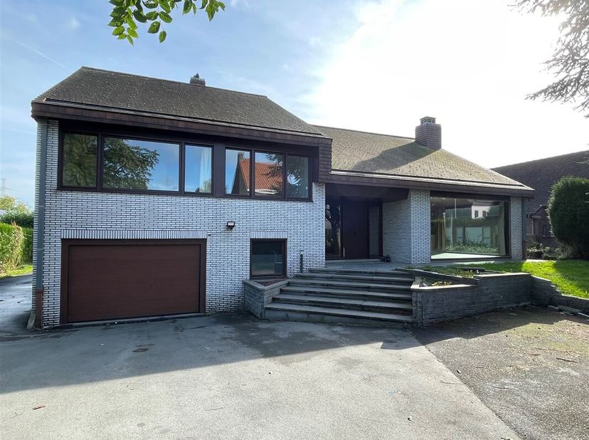 Mooi gelegen grote alleenstaande villa.   Ruime inkom, ruime living met open haard, grote veranda, ruime eetkeuken, toilet en een grote tuin.  Op verd