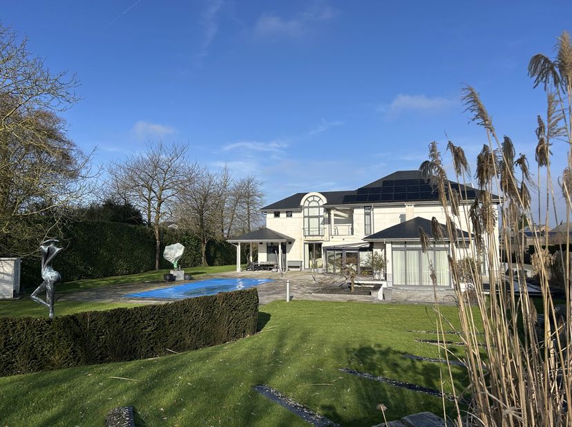 Ideaal gelegen dichtbij Joli-Bois, rust deze elegante en belichte villa uit 2008 met een bewoonbare oppervlakte van ± 443 m² (± 670 m² gebouwd) op een