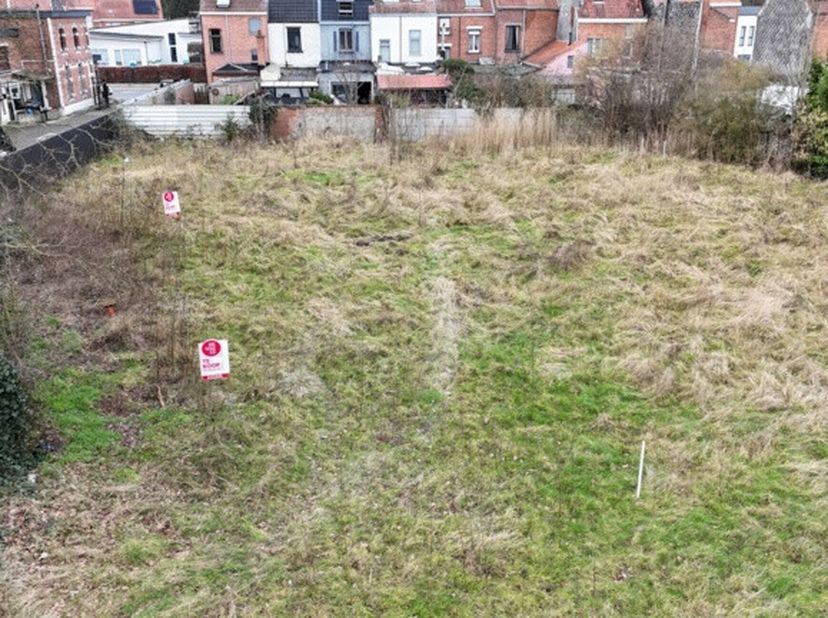 Bouwgrond (544 m2) voor halfopen bebouwing in Rootputhof aan de stadsrand van Sint-Niklaas. De koop omvat, naast de bouwgrond, een aparte parkeerstroo