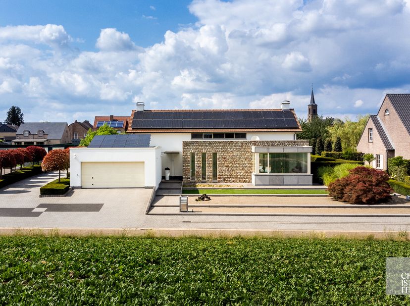 Deze hoogwaardige en ruime villa (323m²) is uitstekend gelegen in de rustige buurt van Kesselt, vlak aan de Nederlandse grens. De woning beschikt over