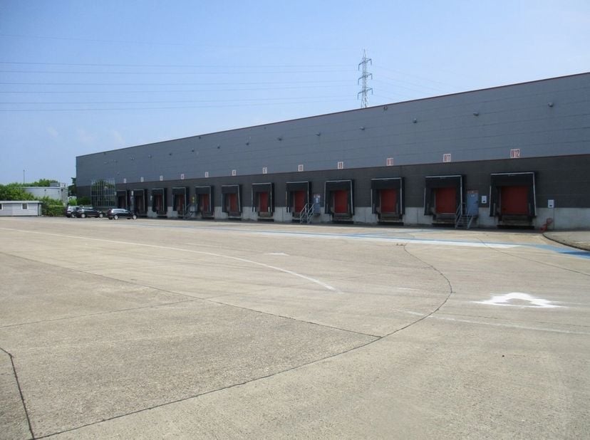 Logistieke site met 6.850m² magazijn (Hal A+E) met 12 los- laadkades, 3.500m² magazijn (Hal B+C) met 4 gelijkvloerse poorten, 590m² kantoren, en verha