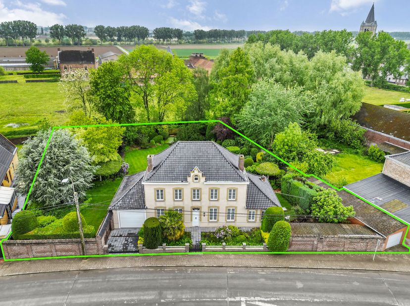 Ontdek deze elegante herenvilla gelegen op 2.100m² in het landelijke Pottes, grenzend aan de taalgrens. Met een bruikbare vloeroppervlakte van maar li