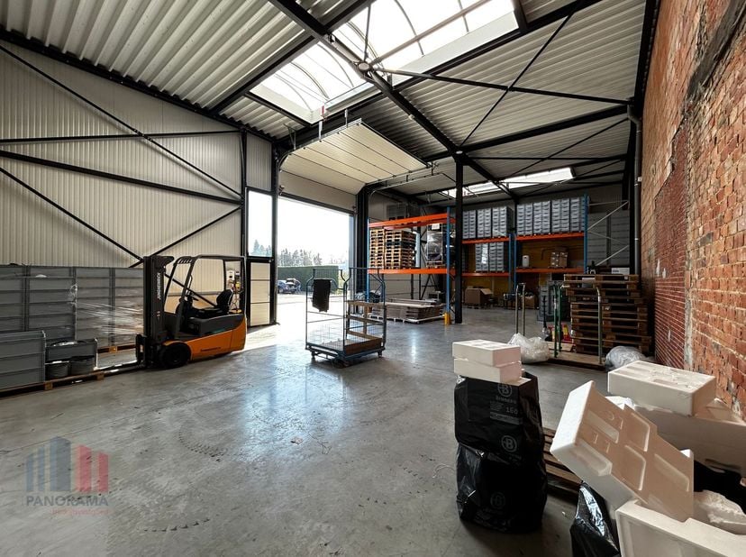 Moderne magazijnruimte van 220m², met twee automatische poorten en een vrije hoogte van 7 meter. Het dak is goed geïsoleerd, voorzien van een steeldec