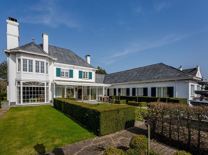 Deze ruime villa, gelegen op 1.450 m² op korte loopafstand van het centrum en de zee in De Haan, biedt een rustige omgeving omgeven door groen. De won