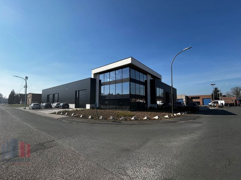 Moderne magazijnruimte van 220m² en kantoor/showroom van 145m² op het gelijkvloers. De magazijnruimte beschikt over twee automatische poorten en een v