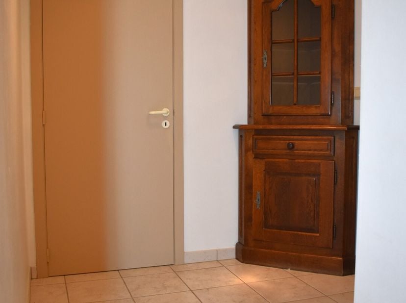 Dit aangenaam lichtrijk appartement is gelegen op het gelijkvloers en omvat een inkom, toilet, ruime leefruimte met open keuken en aanpalende berging,