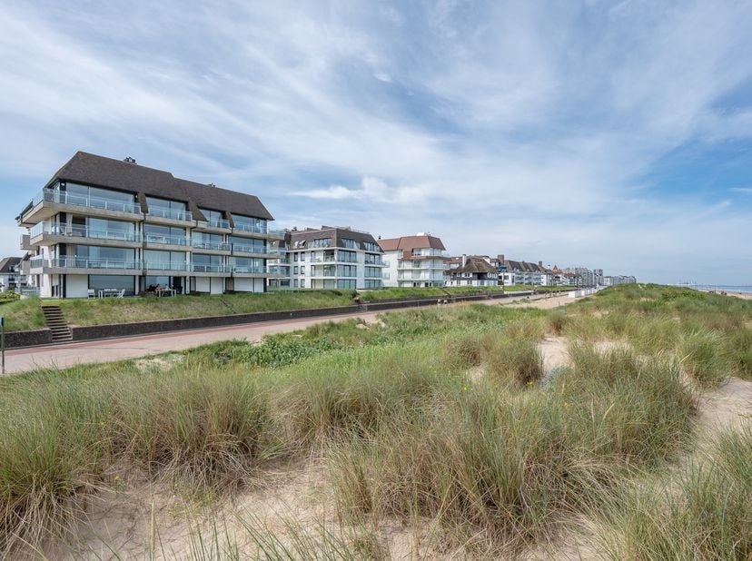 Magnifiek appartement op de wandeldijk in het Zoute, met adembenemend frontaal zeezicht en de duinen. Indeling: inkomhal met vestiaire en gastentoilet