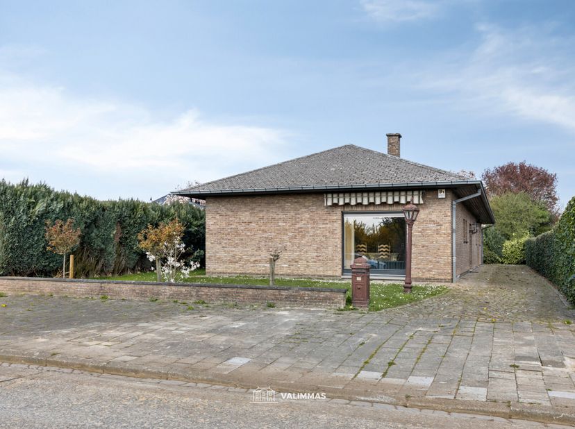 VALIMMAS verkoopt deze welgelegen alleenstaande bungalow met garage en tuin.    Het gelijkvloers bestaat uit een inkomhal, een toilet met handwasbakje