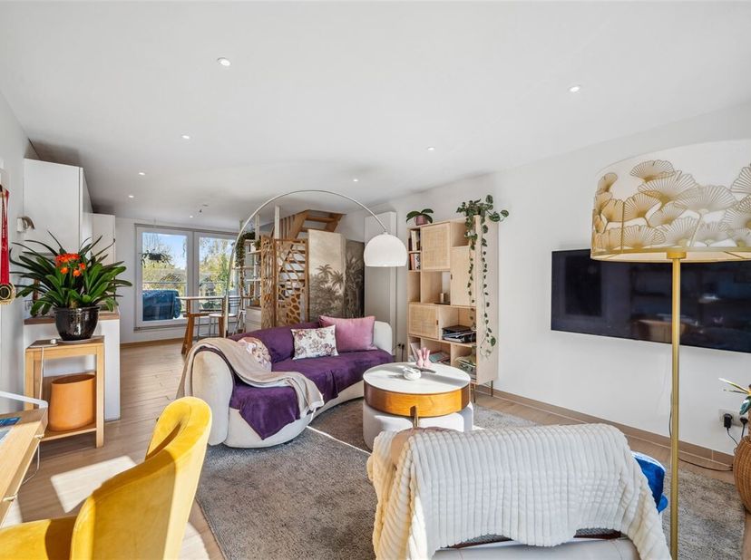 Cette maison, rénovée en 2016, est taillée pour ceux qui tiennent à leur intimité. Une large porte de garage dans la façade en plâtre décoratif blanc