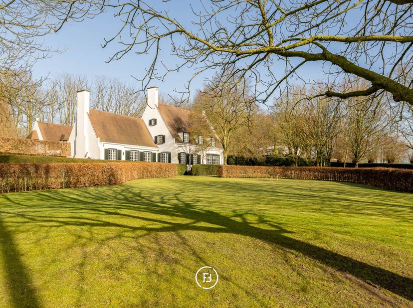 Gelegen in het groene Bellegembos vinden we dit prachtig landhuis ontworpen door Viérin. Via een discrete oprijlaan, omgeven door eeuwenoude bomen, ko