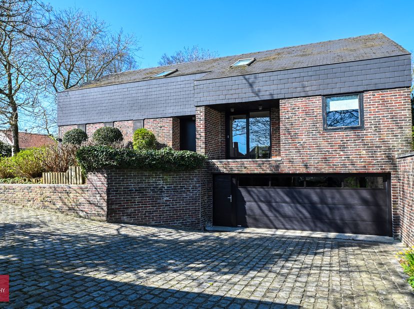 Bestaande uit inkom, eetplaats, tv-hoek, living (gashaard), ruime keuken, berging, gelijkvloerse slaapkamer met badkamer, drie slaapkamers met badkame