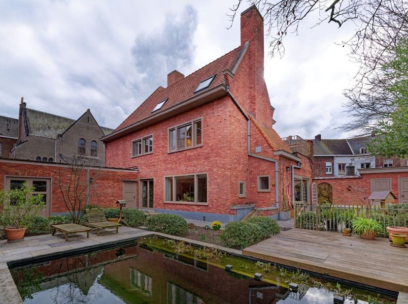 Volledig gerenoveerde burgerwoning van 1946 met twee garages en tuin. Gelijkvloerse praktijkruimte met zicht op binnentuintje, zeer ruime living met p
